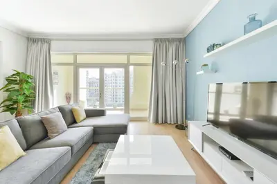 a living room with a couch and a tv at Luxury Beachfront Palm Jumeirah I Free 5 Star Beach Resorts Access in Dubai