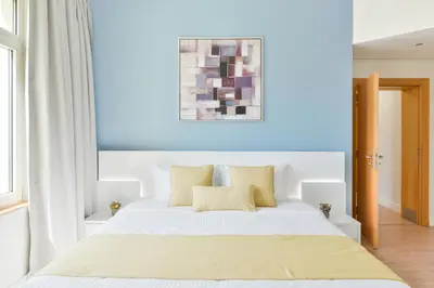 a bedroom with a white bed with yellow pillows at Luxury Beachfront Palm Jumeirah I Free 5 Star Beach Resorts Access in Dubai