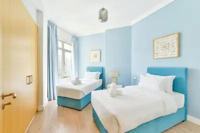 two beds in a room with blue walls at Luxury Beachfront Palm Jumeirah I Free 5 Star Beach Resorts Access in Dubai