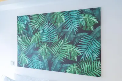 a picture of a green jungle leaves wall mural at Tropical Loft with working station in JVC in Dubai