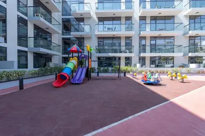 a playground in front of a apartment building at Tropical Loft with working station in JVC in Dubai