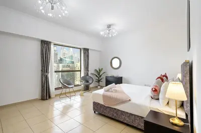 a bedroom with a bed and a large window at 2BR in JBR / Sea View / Dubai Marina / Walk2Beach in Dubai