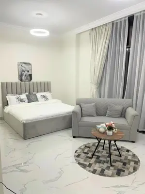 a bedroom with a bed and a couch and a table at Amazing stay in Majan Dubai in Dubai