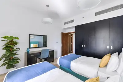 a hotel room with two beds and a desk at Luxury JBR Shams - Marina View - Free 5 star Beach Resorts Access! in Dubai