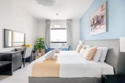 a bedroom with a large bed and a desk at Luxury JBR Shams - Marina View - Free 5 star Beach Resorts Access! in Dubai