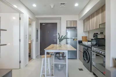a kitchen with a counter with a table in it at City View I 1 Bedroom Apartment I Golf Vita, Damac Hills in Dubai