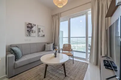 a living room with a couch and a table at City View I 1 Bedroom Apartment I Golf Vita, Damac Hills in Dubai