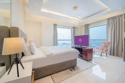 a hotel room with a bed and a television at JBR Rimal , Panoramic Sea and Marina Views, 2m walk to Beach by Gardenia Suites in Dubai
