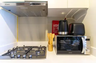 a kitchen with a stove and a microwave at Gala Guests - Marasi Drive City View Apartments in Dubai