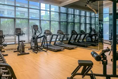a gym with a row of treadms and elliptical machines at Frank Porter - RP Heights in Dubai