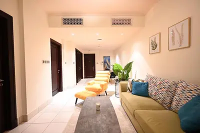 a living room with couches and a table and chairs at Old Town- Heart of Downtown. in Dubai