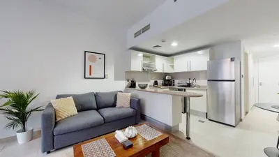 a living room with a couch and a kitchen at DA84 - Chic Studio in Dubai Arch Tower in Dubai