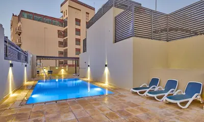 a swimming pool in the middle of a building with chairs at Grand Stay Holiday Homes Al Jaddaf in Dubai