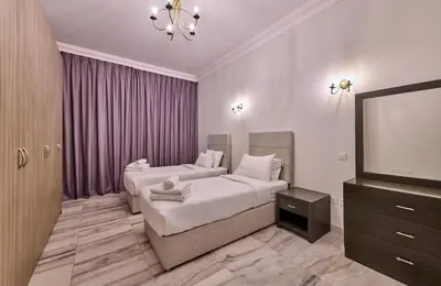 a bedroom with two beds and a flat screen tv at Grand Stay Holiday Homes Al Jaddaf in Dubai
