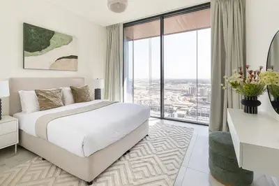 a bedroom with a white bed and a large window at Frank Porter - One Park Avenue in Dubai