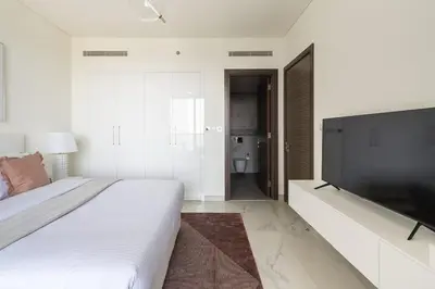 a bedroom with a large bed and a flat screen tv at Frank Porter - One Park Avenue in Dubai