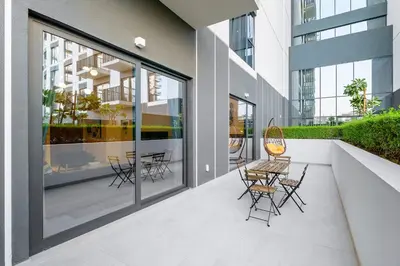a balcony with chairs and tables on a building at Brand New 1BR in Dubai Hills Quiet and Peaceful in Dubai