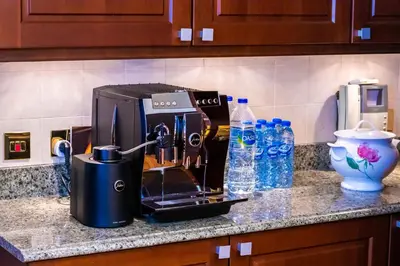 a coffee maker on a counter with bottles of water at Orion in Dubai