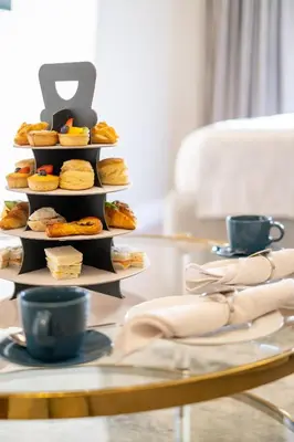 a tray of sandwiches and pastries on a table at Luxury Apt - Rooftop Pool - City View in Dubai