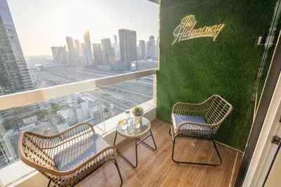 two chairs and a table on a balcony with a view at Luxury Apt - Rooftop Pool - City View in Dubai