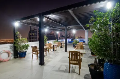 a restaurant with tables and chairs and potted plants at Luxury Apt - Rooftop Pool - City View in Dubai