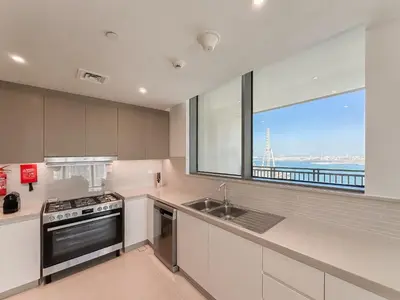 a kitchen with a window and a sink and a stove at Modern 3BR in Marina, Sea View Next to Bluewater - 28AB02 in Dubai