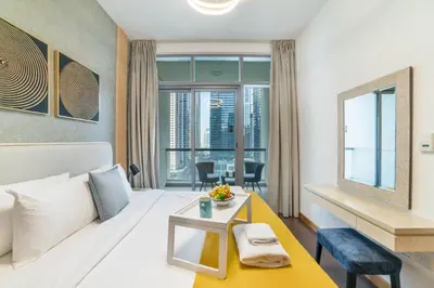 a hotel room with a large bed and a table at Vacay Lettings - Iris blue spectacular Marina view Apartment in Dubai