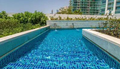a swimming pool with blue water in a city at Spacious 1BD apartment in Address Beach Residence in Dubai