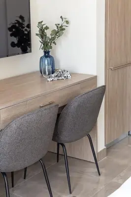 a desk with two chairs and a vase with a plant at Frank Porter - Majestique 1 in Dubai