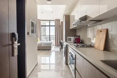a kitchen with a counter and a living room at Frank Porter - Majestique 1 in Dubai