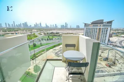 a balcony with a table and two chairs and a city at Luxury Escapes - Brand New Studio with View - Azizi Farhad Jaddaf in Dubai
