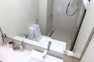 a bathroom with a mirror and a sink and a shower at Superb Studio by The Creek view in Dubai