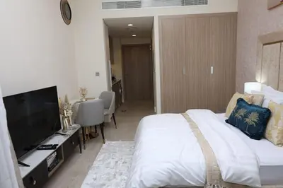 a bedroom with a large bed and a flat screen tv at Superb Studio by The Creek view in Dubai