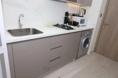 a kitchen with a sink and a washing machine at Superb Studio by The Creek view in Dubai