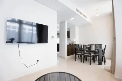 a dining room with a tv and a dining table at Corner 3Bedroom Townhouse in Avencia Cluster DH2 in Dubai