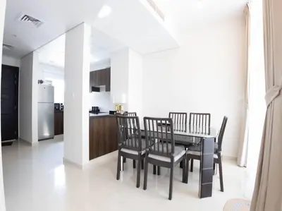 a dining room with a table and chairs and a kitchen at Corner 3Bedroom Townhouse in Avencia Cluster DH2 in Dubai