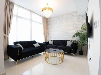 a living room with a black couch and a table at Corner 3Bedroom Townhouse in Avencia Cluster DH2 in Dubai