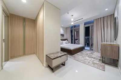 a hotel room with a bed and a television at Paramount Midtown Deluxe 1 BR Apartment with Full Burj-Khalifa View in Dubai