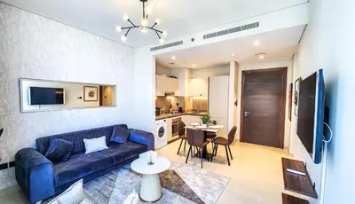 a living room with a blue couch and a kitchen at STAY BY LATINEM Luxury 1BR Holiday Home CV A2304 near Burj Khalifa in Dubai