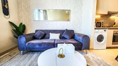 a living room with a blue couch and a table at STAY BY LATINEM Luxury 1BR Holiday Home CV A2304 near Burj Khalifa in Dubai