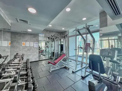 a gym with treadmills and exercise equipment in a building at The Smart Concierge - DEC Tower in Dubai