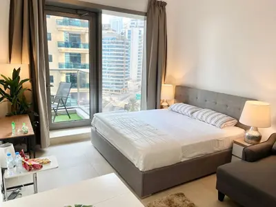 a bedroom with a bed and a large window at Super Elegant studio apartment-Sparkle tower By SWEET HOMES in Dubai