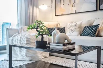 a living room with a glass coffee table with books at The Smart Concierge - Sparkle tower in Dubai