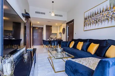 a living room with a blue couch and a table at ONYX - Full Burj Khalifa View Dubai 2 BEDROOM APARTMENT - DOWNTOWN DUBAI in Dubai