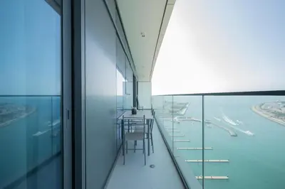 a balcony with a table and chairs in a building at Emaar Beach Vista Tower 1 2BHK FAHH in Dubai
