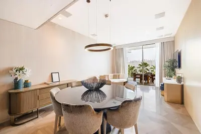 a dining room with a table and chairs at Daniels Five Palm 2BR with Garden View in Dubai