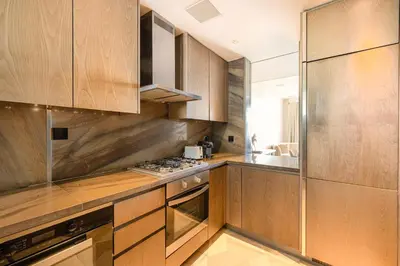 a kitchen with wooden cabinets and stainless steel appliances at Daniels Five Palm 2BR with Garden View in Dubai
