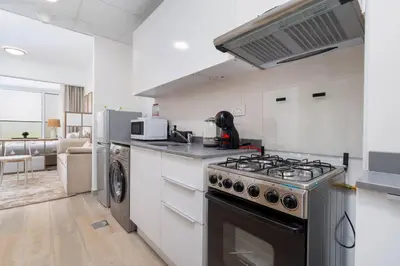 a kitchen with a stove and a dishwasher at Nice Studio in JVC - Pool & Gym in Dubai