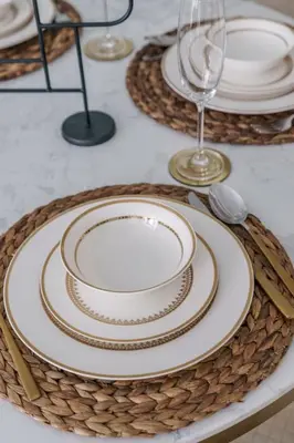 a table with plates and wine glasses on a table at GuestReady - Fabulous 2BR with Burj Khalifa view in Dubai