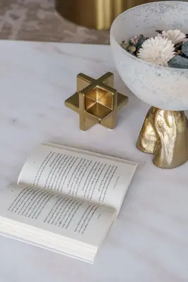 a white table with a book and a bowl and a candle at GuestReady - Fabulous 2BR with Burj Khalifa view in Dubai